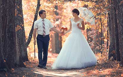 A newlywed couple strolling in the forest